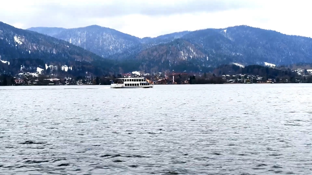 Brod plovi jezerom Tegernsee uz pogled na snežne bavarske planine